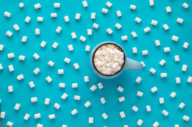 Foto tazza di caffè con marshmallow sul blu.