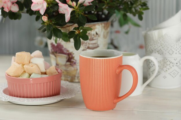 cup of coffee with marshmallow on white wooden table