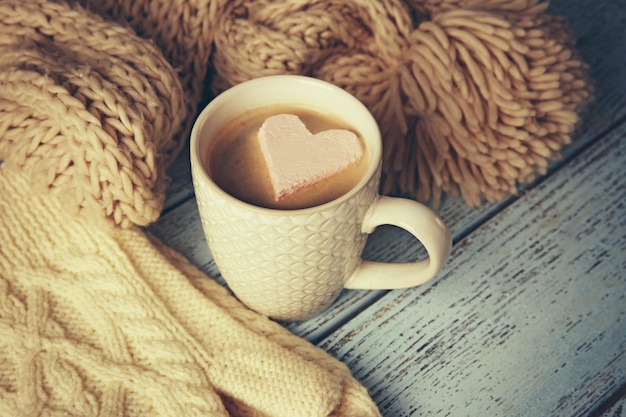 Cup of coffee with marshmallow on wooden table