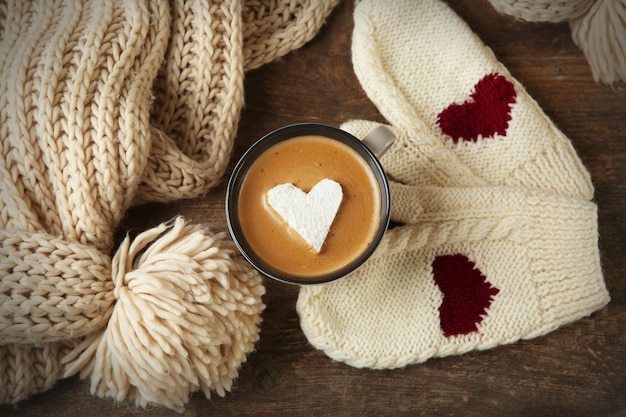 Cup of coffee with marshmallow on wooden table