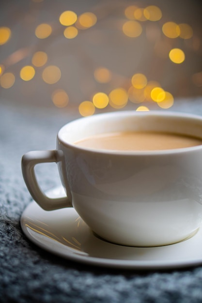 Чашка кофе с молоком на уютном вязаном зимнем одеяле