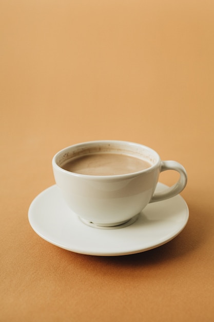 Cup of coffee with milk on ginger