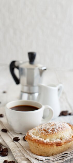 Cup of coffee with pasticciotto pastry on a rustic background close up