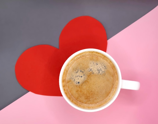 cup of coffee with red heart on a pink background