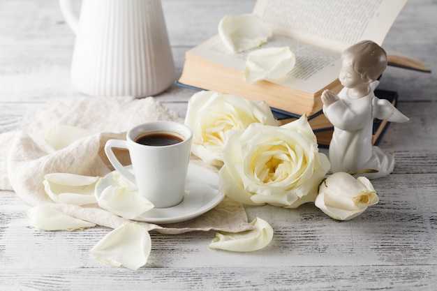 cup of coffee with roses on the wooden surface