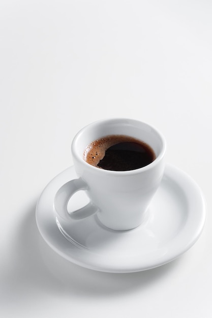 Cup of coffee with saucer on white background close up