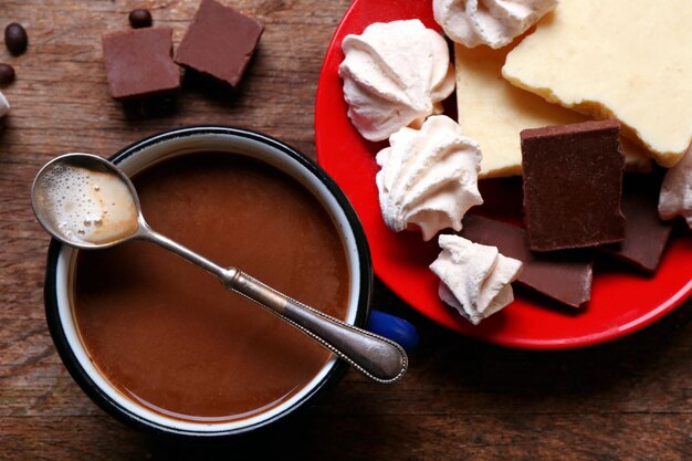 Cup of coffee with sweets on wooden background