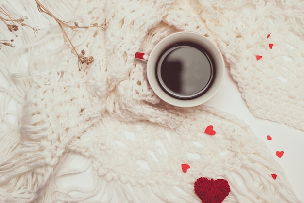 Tazza di caffè con calda sciarpa lavorata a maglia