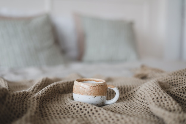 Cup of coffee with warm plaid Breakfast in bed