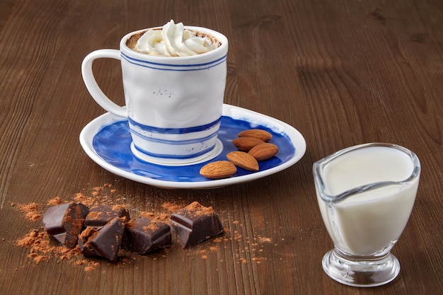 Cup of coffee with whipped cream and almonds