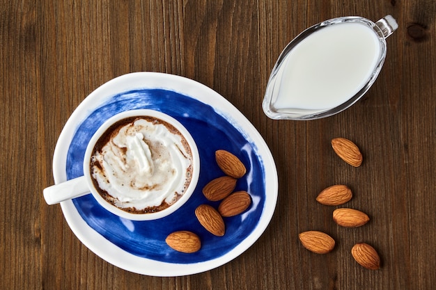 Cup of coffee with whipped cream and almonds