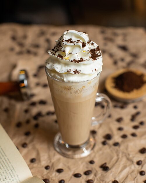 A cup of coffee with whipped cream on top of it.