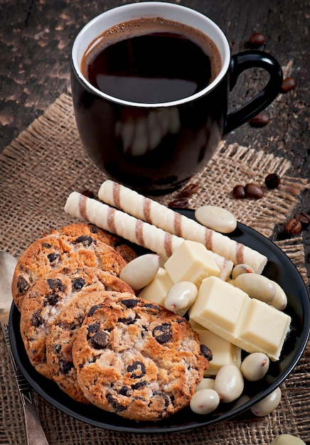 Чашка кофе с белым шоколадом, миндалем и печеньем.