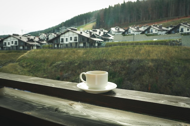 Tazza di caffè sul balcone di legno nella stazione sciistica