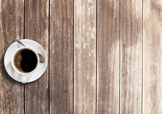 Cup of coffee on wooden table background