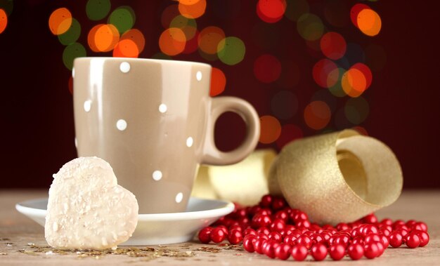 Cup of coffee on wooden table on bright bokeh backdground