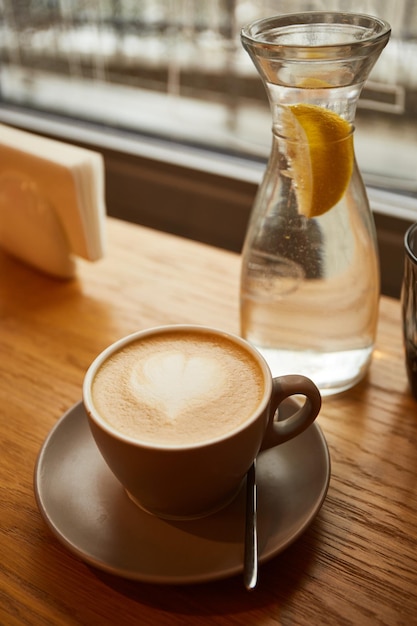 카페 카푸치노 또는 머그잔에 담긴 라떼의 나무 테이블에 있는 커피 한 잔 혼자 시간 즐기기