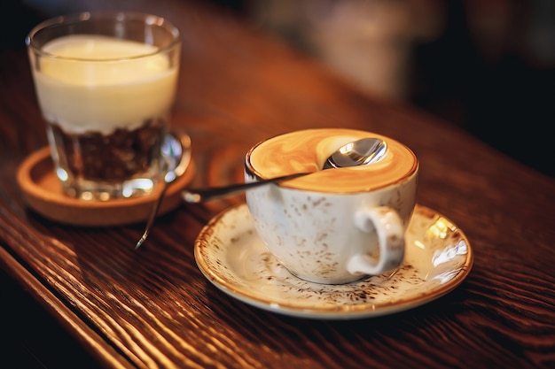 Foto tazza di caffè su un tavolo di legno. copia spazio cucchiaio sulla schiuma con caffè che non affonda