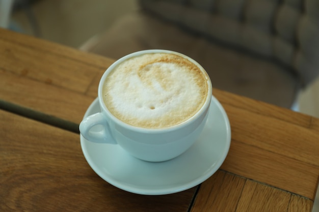 Cup of coffee on wooden table in restaurant