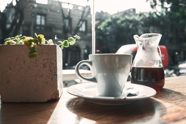 Cup of coffee on a wooden table in a stained glass window