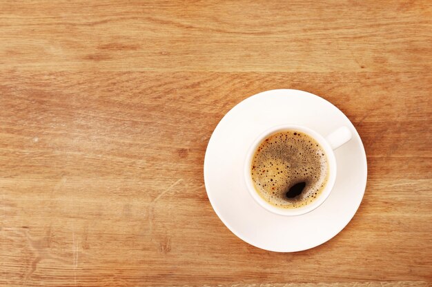 Cup of coffee on wooden table top view