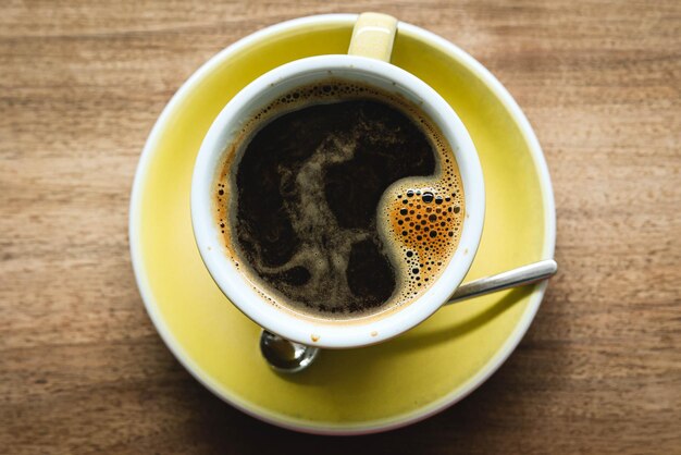 A cup of coffee on a wooden table.