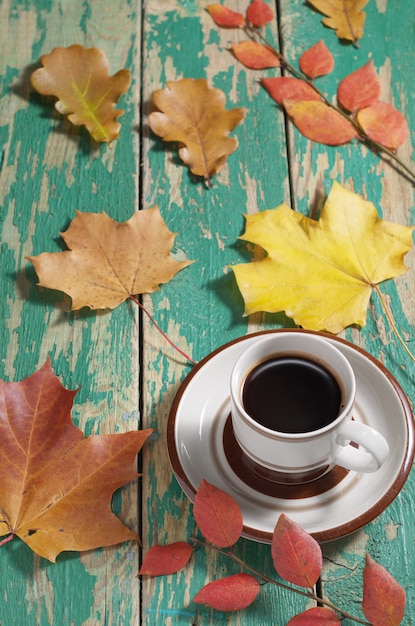 一杯のコーヒーと黄色の紅葉