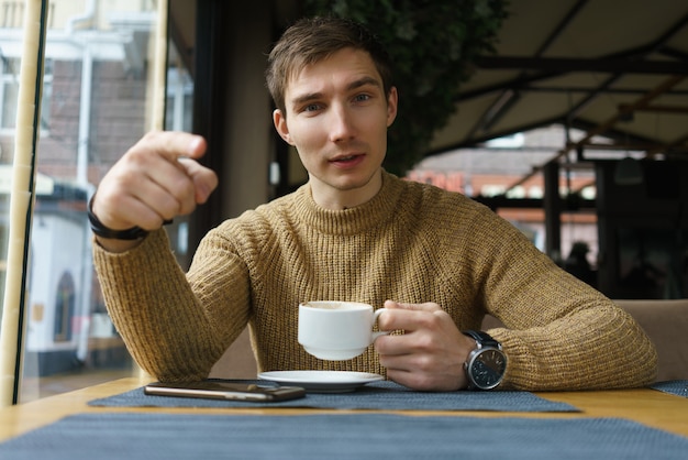 Photo cup of coffee and young man