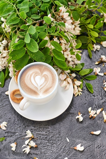 Cup of coffeel and acacia closeup. Nutrition. table with a cup of Coffee and acacia flowers.