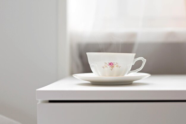 Cup of coffeetea standing on the cupboard in bedroom