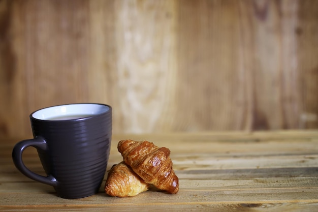 Cup croissant breakfast wooden background