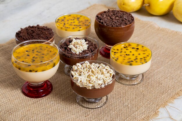 Cup of dessert with milk chocolate mousse and white chocolate shavings, ganache mousse and passion fruit mousse.