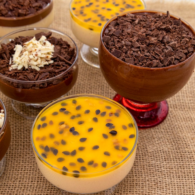 Cup of dessert with milk chocolate mousse and white chocolate shavings, ganache mousse and passion fruit mousse.