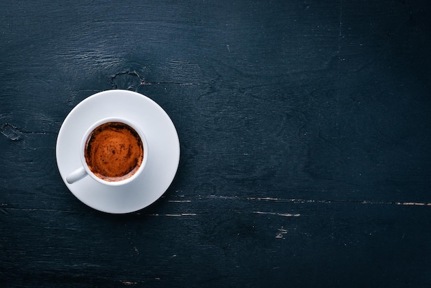 A cup of espresso coffee on a dark wooden background Top view Free space for text