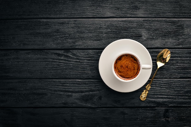 Una tazza di caffè espresso su uno sfondo di legno scuro. vista dall'alto. spazio libero per il testo.