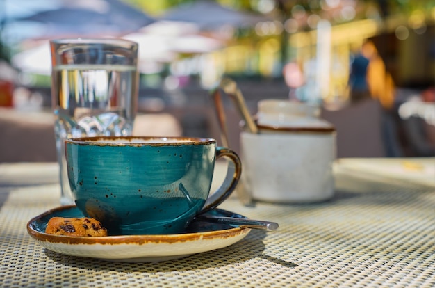 Cup of espresso coffee a glass of water and cookies on the table closeup selective focus white space cafe breakfast advertising or banner