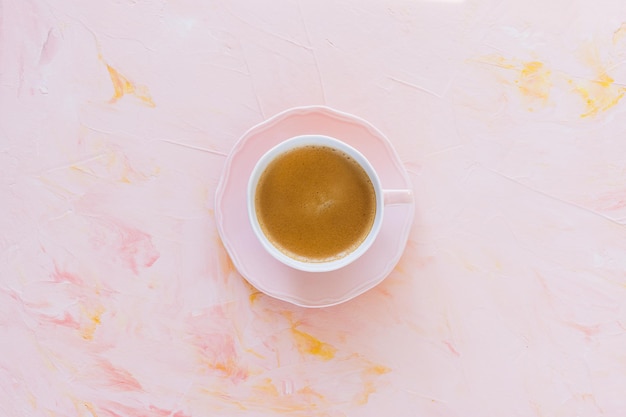 Cup of espresso coffee on pink background