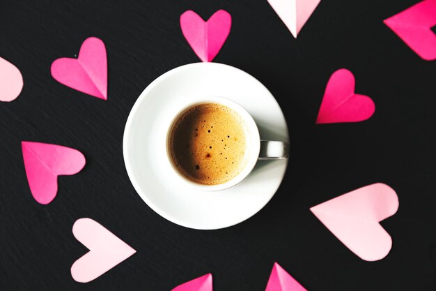 Cup of espresso coffee with  valentine. Black background, selective focus.