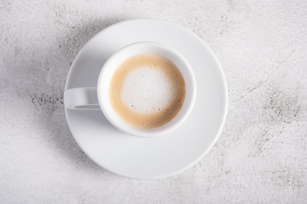 A cup of espresso macchiato on a light background for breakfast