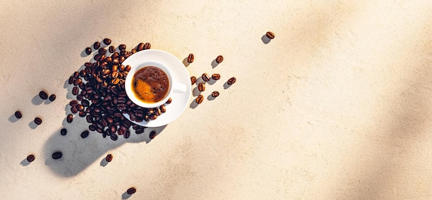 Cup of espresso with coffee crema on stone texture in morning sunlight