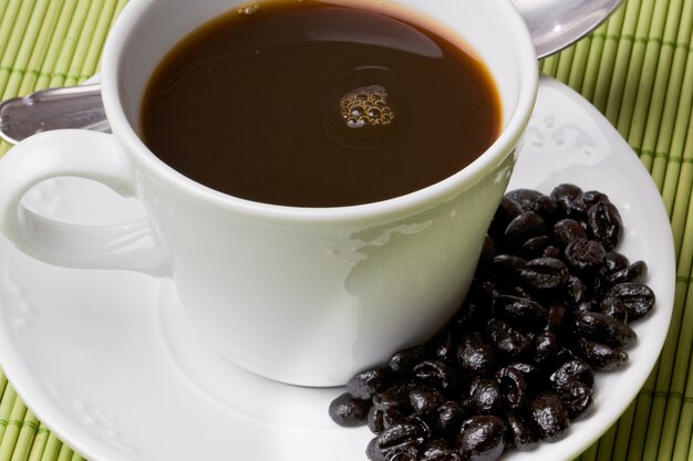 Cup of expresso coffee on a green tablecloth