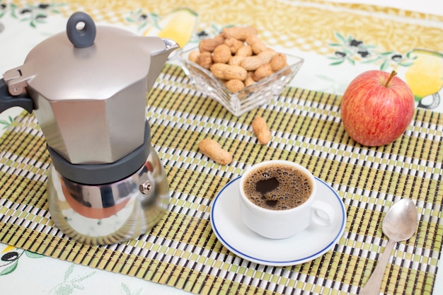 Tazza di caffè espresso con arachidi e frutta