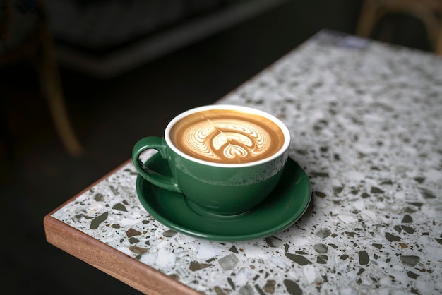 Cup of flat white coffee in a green cup with beautiful latte\
art