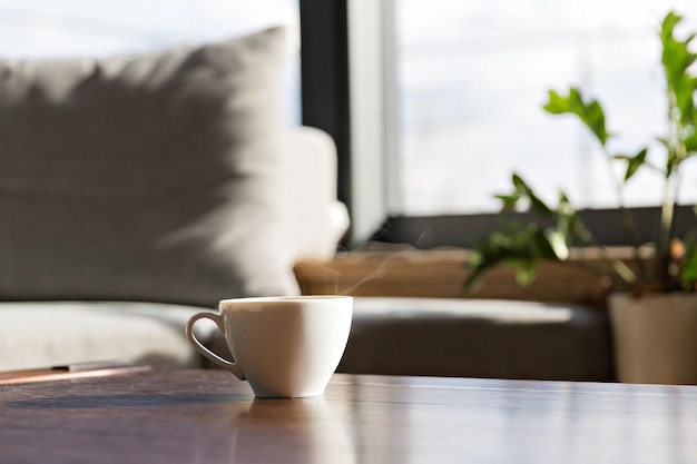 Cup of fresh coffee standing on the table against window