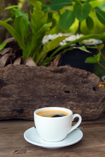 Cup of fresh coffee with coffee beans on wooden table