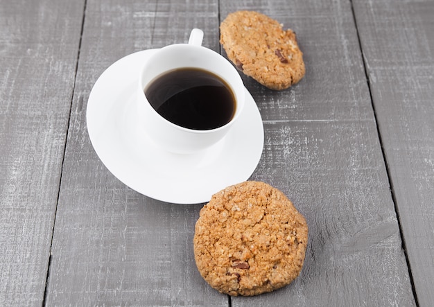 木の板で朝食にクッキーと新鮮なコーヒーのカップ