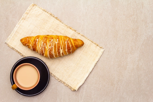 クロワッサンとfreshれたてのコーヒー。石の背景のコンセプト