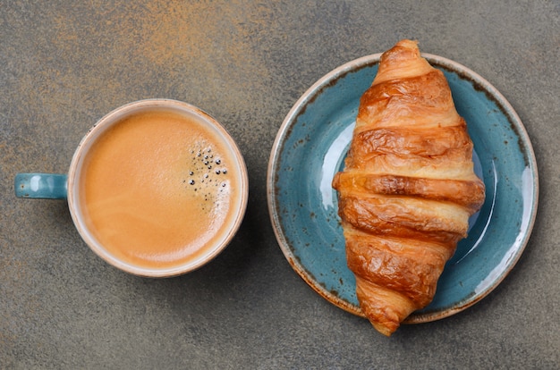 Foto tazza di caffè fresco con cornetto.