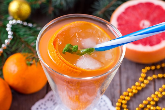 冬とクリスマスのための新鮮なオレンジジュースのカップ