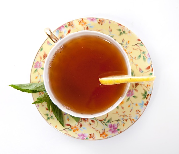 Cup of fresh tea with mint leaves and lemon